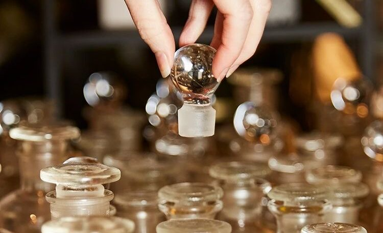 hand placing a cover on the perfume